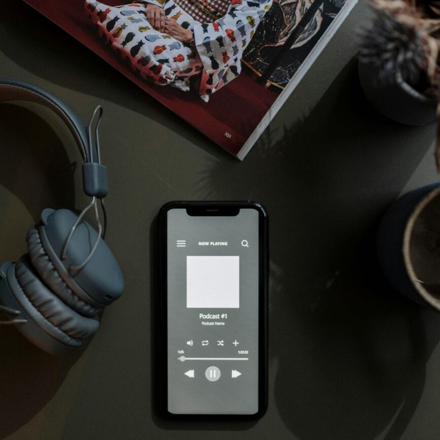 overhead shot of a cellphone between a mug and headphones