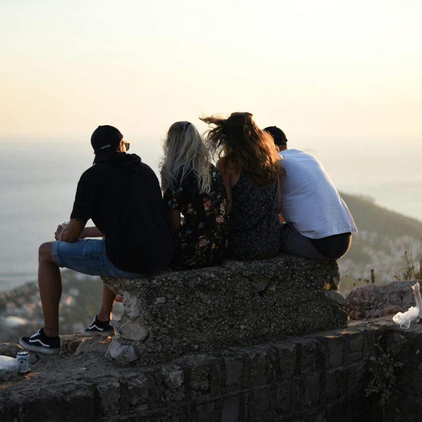 men and women sitting on concrete bench