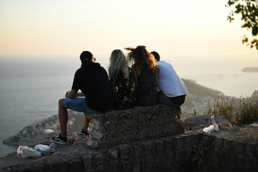 men and women sitting on concrete bench