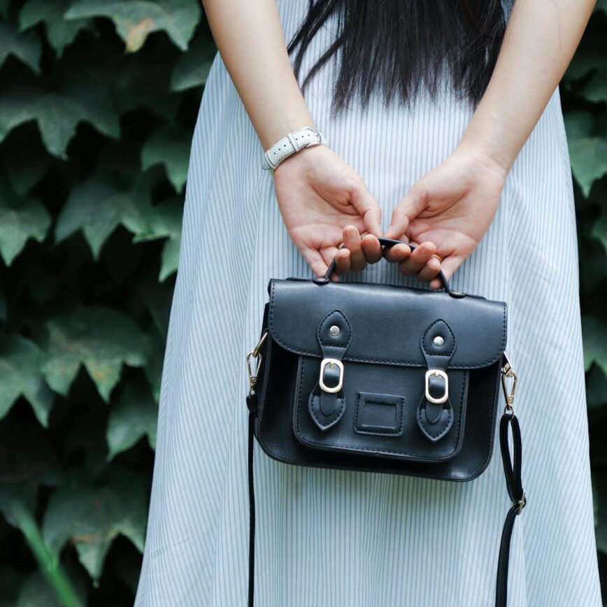 woman holding black leather bag