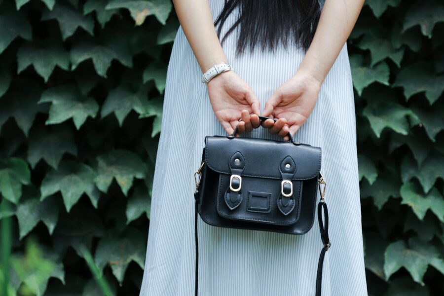 woman holding black leather bag